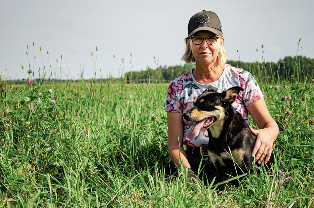 Kvinna med hund i högt gräs