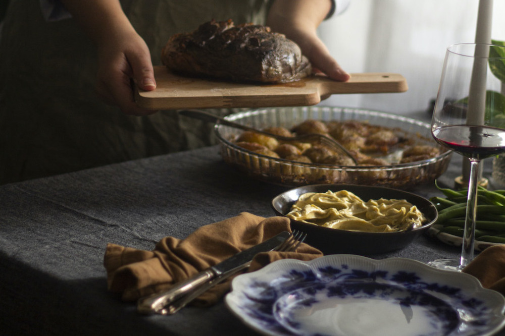 Middagsbord med lammstek på skärbräda
