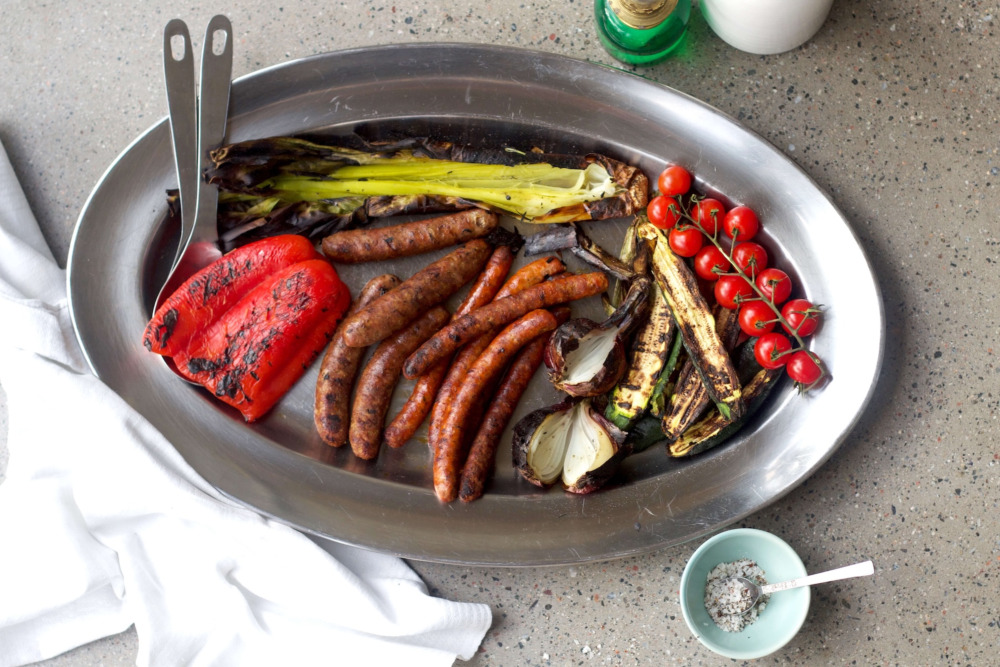 Korv och grillade grönsaker på ovalt fat i metall
