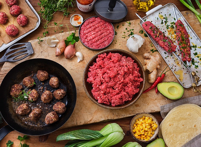 Färs på skärbräda. Stekta köttbullar. Hamburgare och kebab.