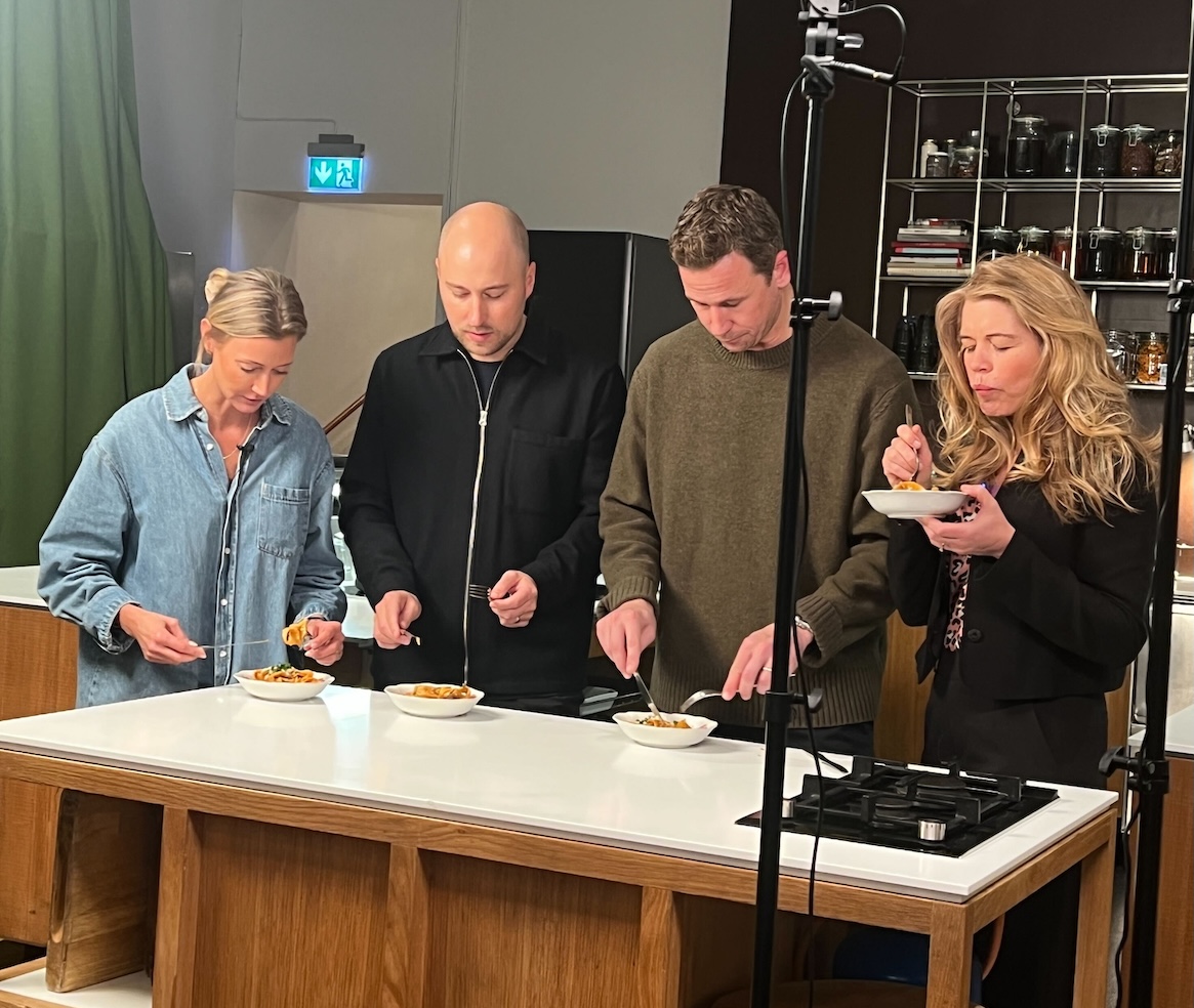 Fyra personer står vid ett bord och testar mat