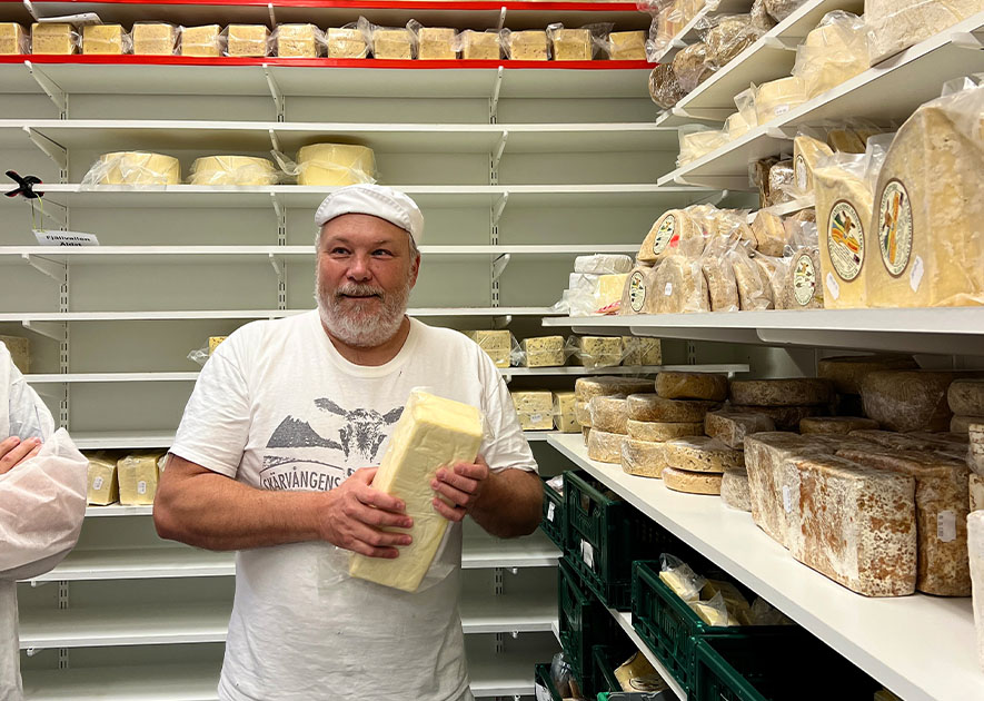 Man som håller i ett stort ostblock